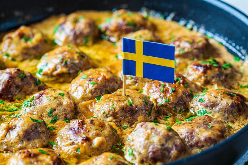 Boulettes de viande suédoises dans une sauce crémeuse dans une poêle à frire noire, fond gris, gros plan. Scandinave p...